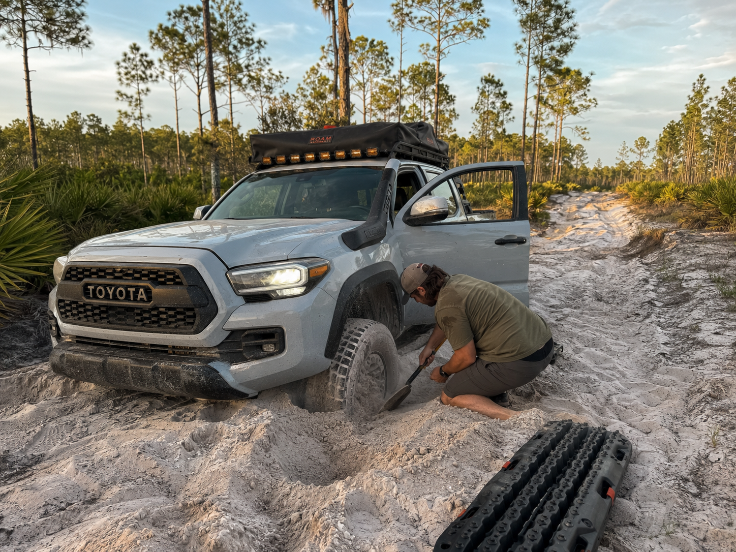 Technician inspecting steering and suspension on a lifted truck