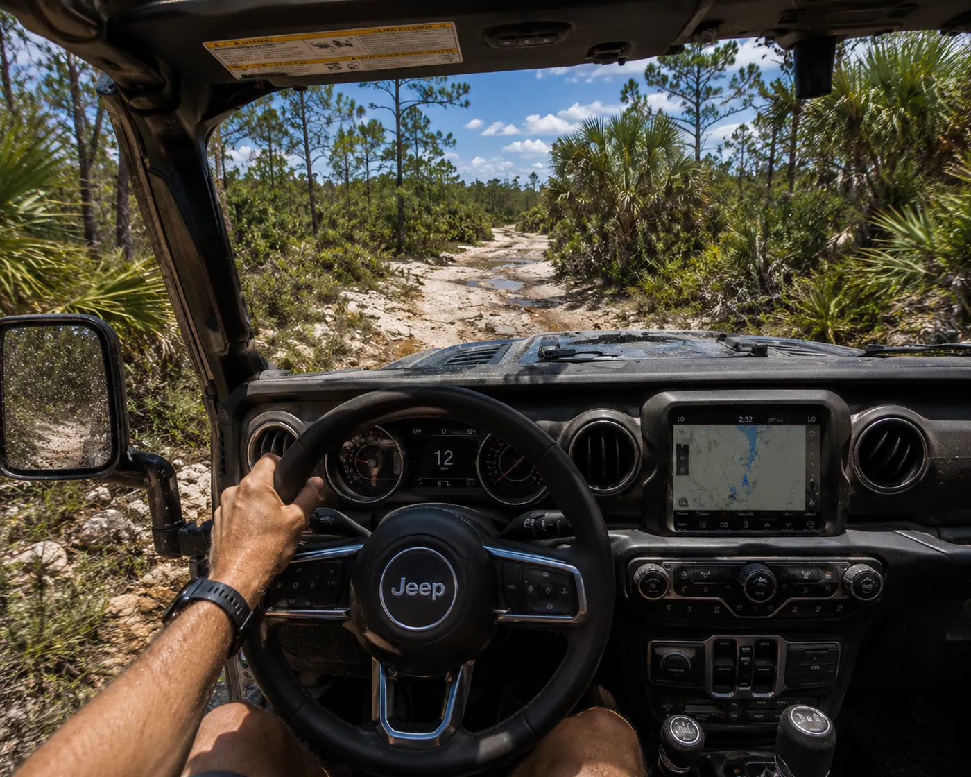 Driver's POV from inside a Jeep Wrangler on a sandy Florida pine-flatwoods trail